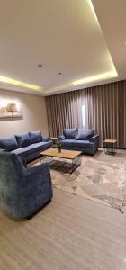 a living room with two couches and a table at شقق ظلال النخيل in Al Khobar