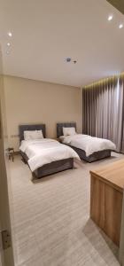 two beds in a large room with at شقق ظلال النخيل in Al Khobar