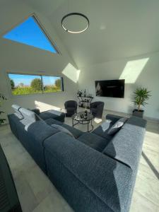 a living room with a blue couch and a large window at TY MENEZ HEOL - Magnifique villa avec piscine in Ploudalmézeau