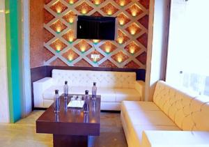 uma sala de estar com um sofá e uma televisão em Mayur Palace By WB Inn em Agra