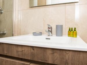 lavabo blanco en el baño con espejo en Stamatina's Luxury Apartments (Central 3rd floor), en Alexandroupoli