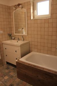 ein Badezimmer mit einer Badewanne, einem Waschbecken und einem Spiegel in der Unterkunft Josefín in Němčičky