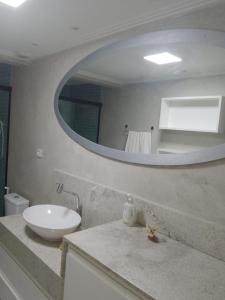 a bathroom with a sink and a mirror at Apartamento Perto Praia in Salvador