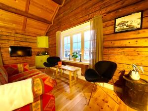 a living room with a couch and chairs in a log cabin at The blacksmith's place - Cozy Rorbu in Lofoten in Sørvågen