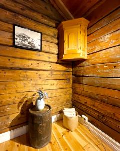 a log cabin bathroom with a wooden wall at The blacksmith's place - Cozy Rorbu in Lofoten in Sørvågen