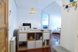 a living room with a table in a room at Apartamento con terraza a un paso de la playa in Gijón +8 photos