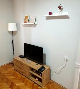 - un salon avec une télévision à écran plat sur une armoire en bois dans l'établissement Fenix Apartman, à Zaječar