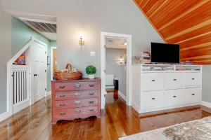 a bedroom with a dresser with a tv on it at The Apartment at Camp Hattie Wolfeboro in Wolfeboro