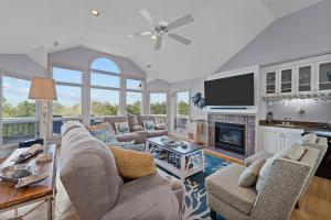 a living room with couches and a fireplace at Sea Pride in Corolla