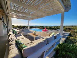 une terrasse avec un canapé, une table et une piscine dans l'établissement Sunbird House, à Grotto Bay