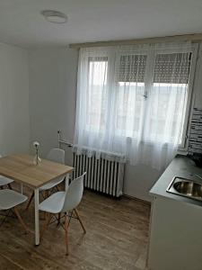 - une cuisine avec une table, des chaises et un évier dans l'établissement Fenix Apartman, à Zaječar