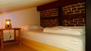 a bedroom with two beds and a brick wall at Hoeve Espewey - Studio 