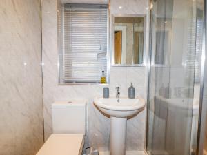 a bathroom with a sink and a toilet and a shower at Church View Cottage in Doncaster