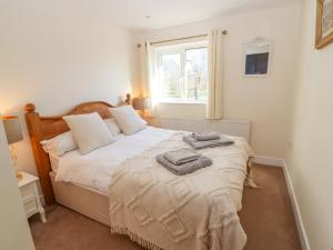 a bedroom with a bed with two towels on it at Church View Cottage in Doncaster