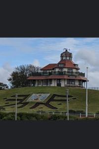 a large house on top of a hill with a building at Lovely Centralised 1Bed Apt Near Town Centre & Beach - Free Wi-Fi & Parking in Fleetwood