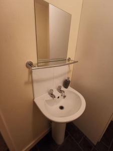 ein Badezimmer mit einem weißen Waschbecken und einem Spiegel in der Unterkunft Lovely Centralised 1Bed Apt Near Town Centre & Beach - Free Wi-Fi & Parking in Fleetwood
