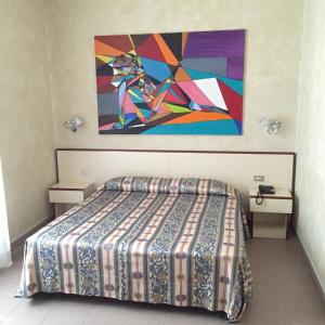 a bedroom with a bed and a painting on the wall at Le Petit Hotel in Turin