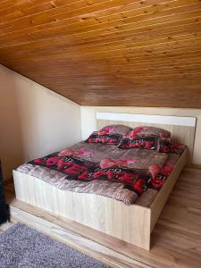 Bett in einem Zimmer mit Holzdecke in der Unterkunft Vivien vendégház in Zamárdi