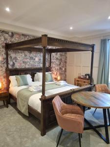 1 dormitorio con cama con dosel y mesa en The Resolution Hotel, en Whitby