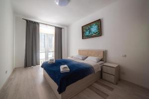 1 dormitorio con 1 cama con manta azul y ventana en Zarinok House, en Skole