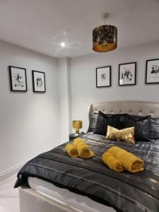a bedroom with a large bed with yellow pillows at Stunning Sea View Two Bed Two Bathroom Apartment in Porthcawl