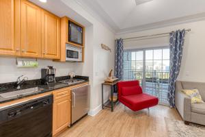 a kitchen with a red chair in a room at Beachside Waterview 2Br Condo w/ Pool in Greenport in Greenport
