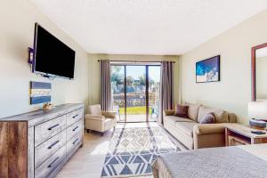 a living room with a television and a couch at Pirates Bay B109 in Fort Walton Beach