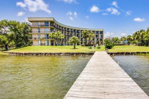 a building next to a body of water with a dock at Pirates Bay B109 in Fort Walton Beach