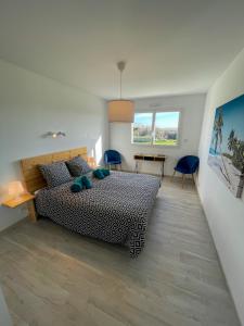 a bedroom with a bed and a table and chairs at TY MENEZ HEOL - Magnifique villa avec piscine in Ploudalmézeau