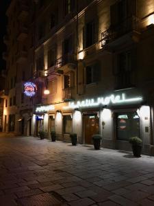 an empty street at night with a hotel at Le Petit Hotel in Turin