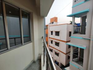 - un balcon dans un bâtiment avec deux fenêtres dans l'établissement Stylish 2BHK Service Apartment Near Golpark, à Kolkata