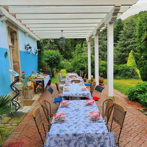 una larga fila de mesas en un patio con sillas en La Casona Azul, espectacular palacio indiano, en Corvera