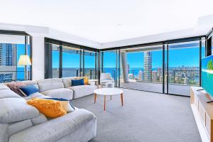 a living room with a couch and large windows at Circle On Cavill Surfers Paradise Apartments-Holiday Paradise in Gold Coast