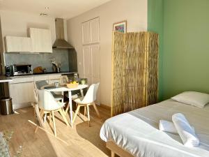 - une chambre avec un lit, une table et des chaises dans l'établissement La Paillote Dieppoise vue port exceptionnelle 2 à 4 pers, à Dieppe