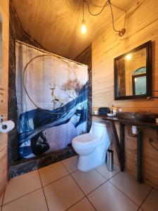 uma casa de banho com WC e uma pintura na parede em CABAÑAS ALTO BELLAVISTA NIEBLA em Niebla