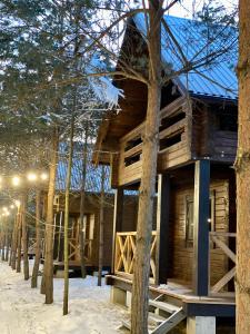 una cabaña de madera en el bosque en la nieve en Family Resort en Mostiska
