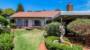 a house with a garden with a statue in the yard at BEDFORDVIEW BandB in Bedfordview