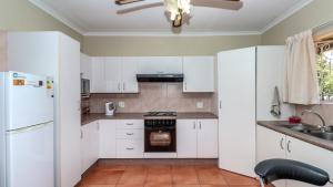 eine Küche mit weißen Schränken und einem weißen Kühlschrank in der Unterkunft BEDFORDVIEW B&B ENTIRE ONE BEDROOM CLUSTERs in Bedfordview