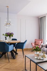 een woonkamer met een eettafel en stoelen bij Modern Apart 23 in Olsztyn
