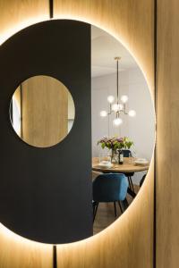 uma sala de jantar com um espelho circular e uma mesa em Modern Apart 23 em Olsztyn