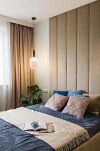 a bedroom with a bed with a book on it at Modern Apart 23 in Olsztyn