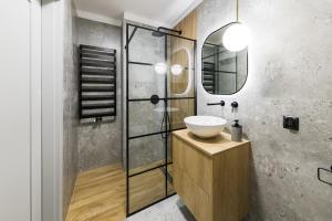 a bathroom with a sink and a mirror at Modern Apart 23 in Olsztyn