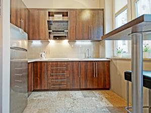 a kitchen with wooden cabinets and a sink at Apartament Kameralny V in Gdańsk