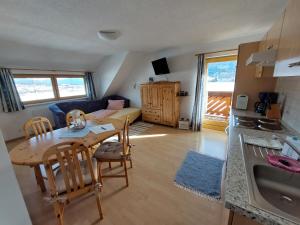 eine Küche und ein Wohnzimmer mit einem Tisch und Stühlen in der Unterkunft Moser Jaggeihof in Mariapfarr