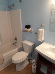 a bathroom with a white toilet and a sink at Chateau DeVille of West Shreveport in Greenwood