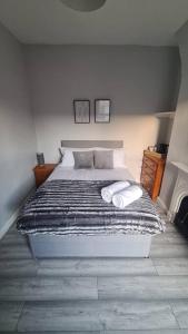 een slaapkamer met een bed met twee handdoeken erop bij Entire House Near City Centre with Parking Permit (3 bedrooms, Sleeps 8) in Liverpool