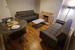 een woonkamer met een bank en een tafel bij Entire House Near City Centre with Parking Permit (3 bedrooms, Sleeps 8) in Liverpool