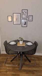 a black table with chairs and pictures on the wall at Entire House Near City Centre with Parking Permit (3 bedrooms, Sleeps 8) in Liverpool