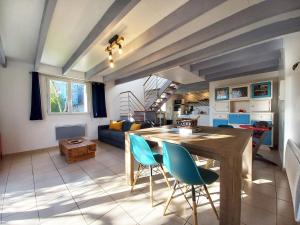 cocina y sala de estar con mesa de madera y sillas en Gîte Les Cerisiers, en Binic