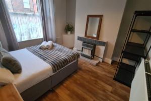 a bedroom with a bed with a fireplace and a mirror at Entire House Near City Centre with Parking Permit (3 bedrooms, Sleeps 8) in Liverpool